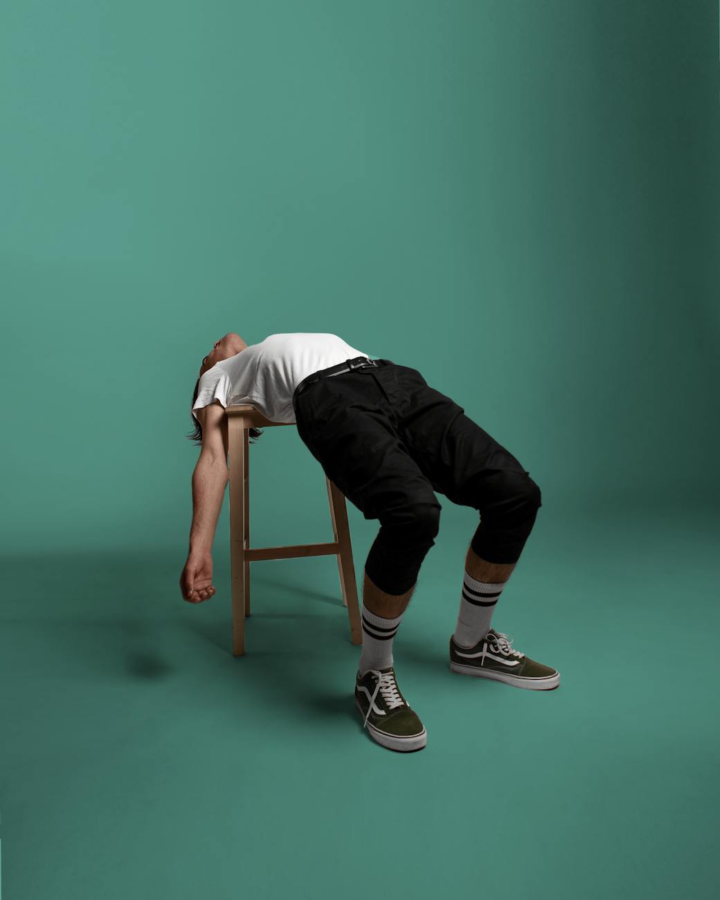 a male model reclining on a stool